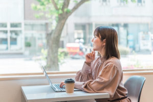 カフェでパソコンを使用する女性の横顔
