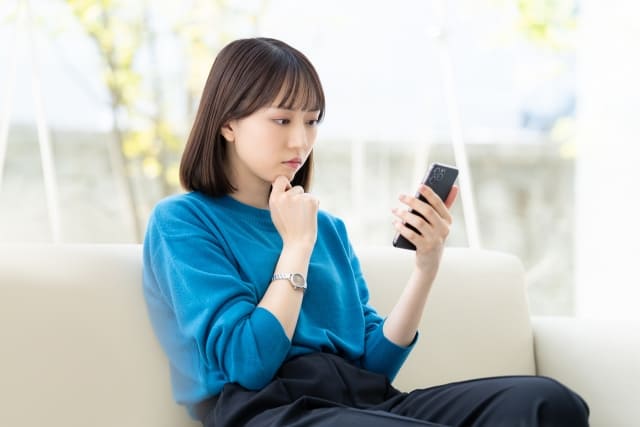 ネイルサロンの予約を悩む女性