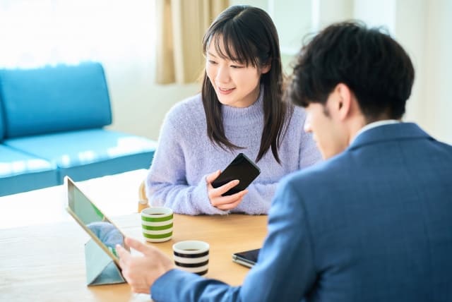 サラリーマンの話を聞く若い女性