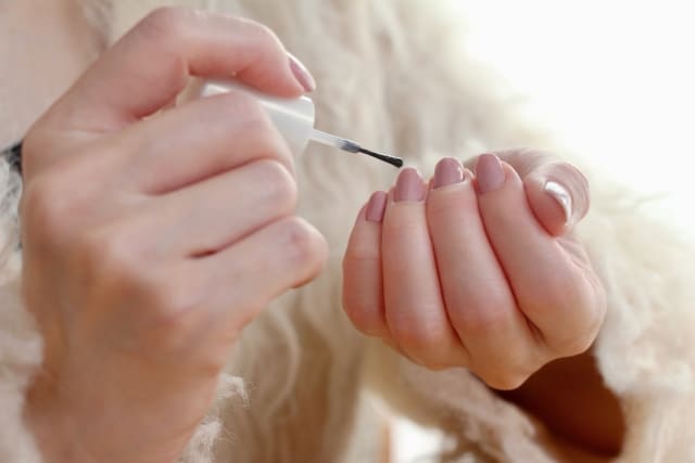 セルフネイルでジーニッシュを使用する女性の手元